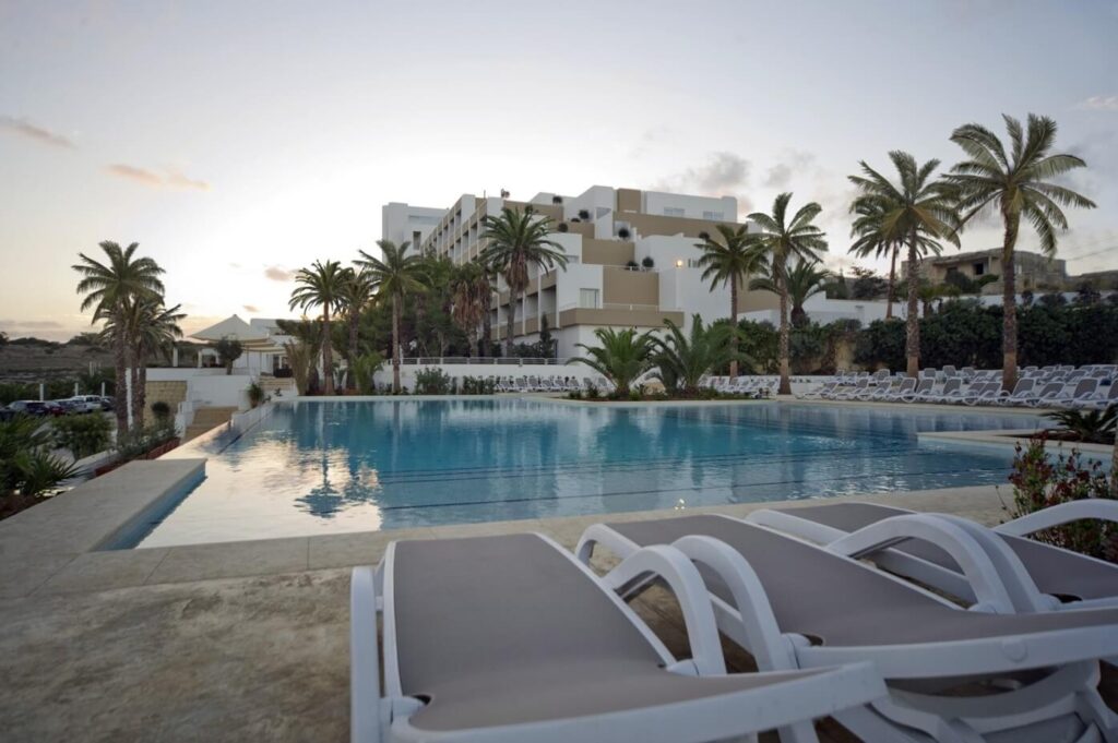 Vonkajší bazén v Salini Resort Malta s lehátkami